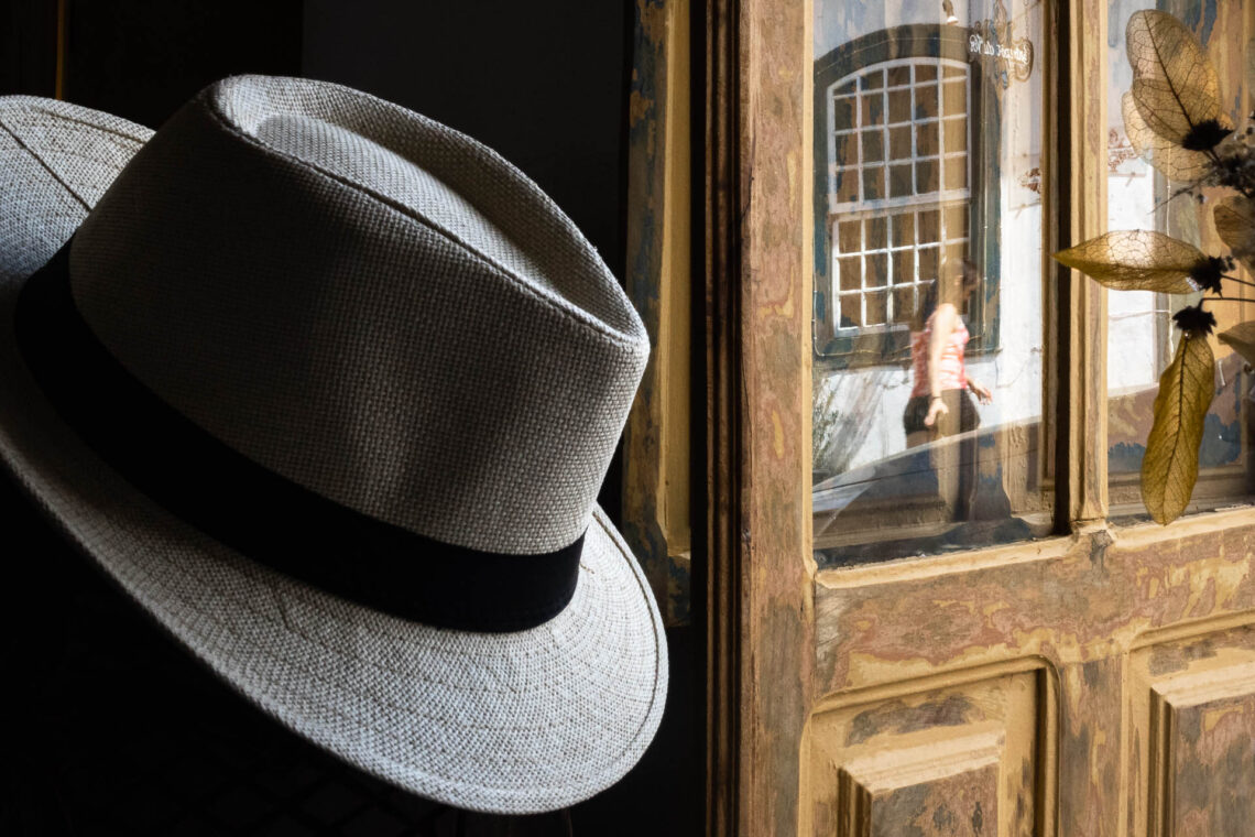 Chapéu, janela e folhas secas