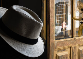 Chapéu, janela e folhas secas