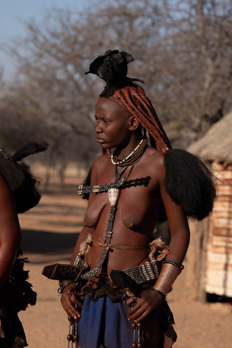 Aurora Himba
Legenda: Uma jovem se levanta com o primeiro sol. Seu corpo fala em adornos e silêncio — tradição que desperta com ela.