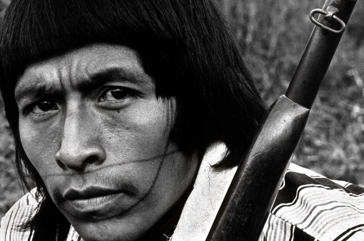 Transformações entre os Surui Paiter- (RO, 1978)
Desde o contato oficial em 1969, a interação com os não indígenas trouxe profundas mudanças sociais para os Paiter. Contudo, sua índole guerreira permanece viva, impulsionando a luta pelo reconhecimento e integridade de seu território. Atualmente, Txai Suruí se destaca como uma importante líder indígena, defensora dos direitos humanos, da justiça ambiental e da preservação da floresta.