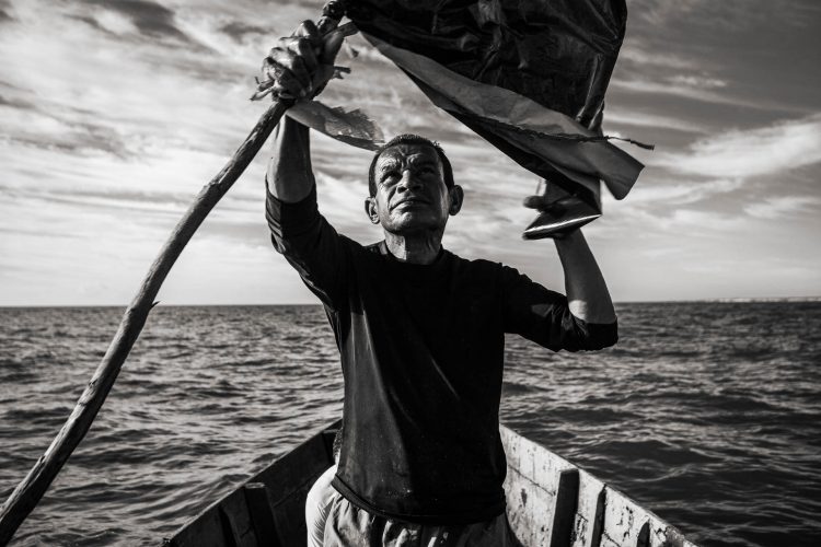 Mar da Bahia. Em um dia comum, os de lua minguante ou crescente, a atividade é a pesca de espera. Lança-se a rede ao mar com suas bandeiras flutuantes.