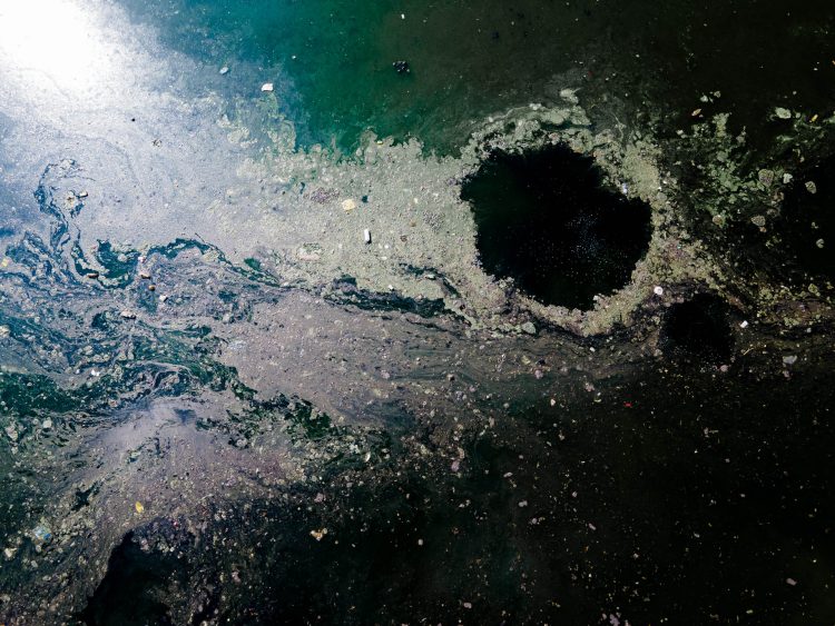 Imagem aérea, do Rio Pinheiros. Parte da série Tempos Descartáveis e da exposição Big Bang: Reflexos Universais a imagem traz uma perspectiva abstrata, subjetiva e reflexiva da poluição plástica em nossos rios.