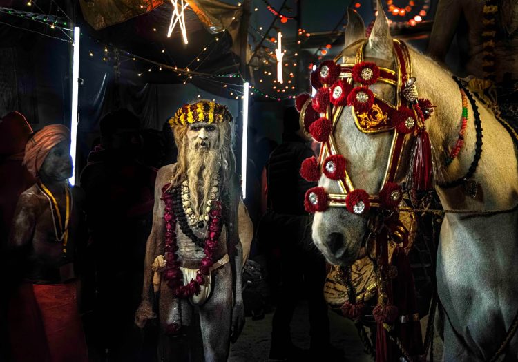 Como uma cena saída de um filme, o sadhu e o cavalo sagrado dividem o mesmo silêncio, entre luzes que não explicam nada, apenas revelam. Tudo ali parece suspenso, como se o tempo tivesse parado para que o mistério se mostrasse, por um instante. Trocamos olhares. Os dois surpresos com o que vêem...