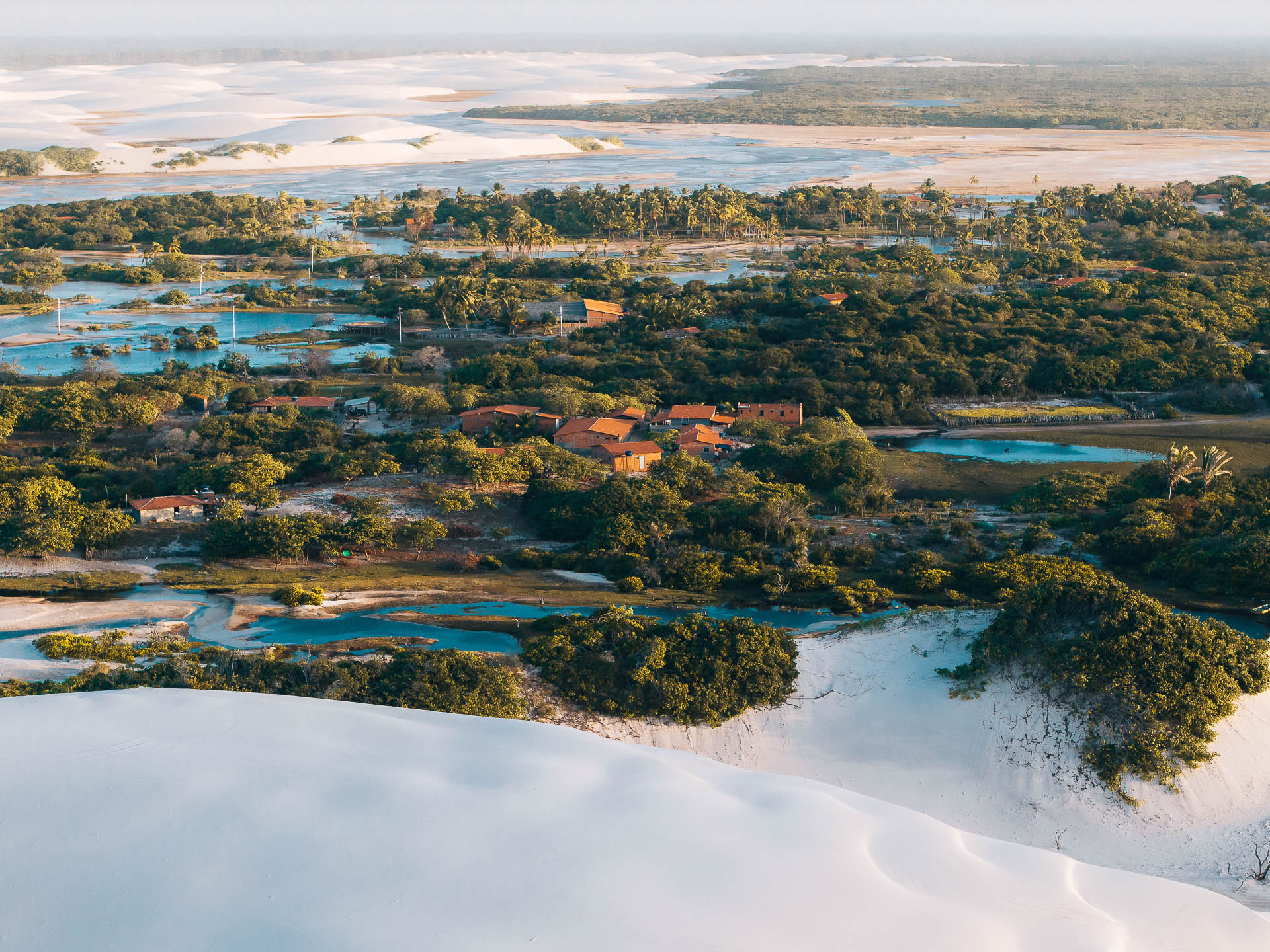 Betânia
No oásis de Betânia, território abraça quem chega e quem nunca saiu. Famílias que moram em casas de tijolo onde a areia invade o quintal. Turistas que vêm fotografar o paraíso. Trilheiros que cruzam deserto procurando água cristalina. Restaurantes servem quem vem de fora, panela no fogão alimenta quem fica. Terra que virou Parque Nacional, mas nunca deixou de ser casa.