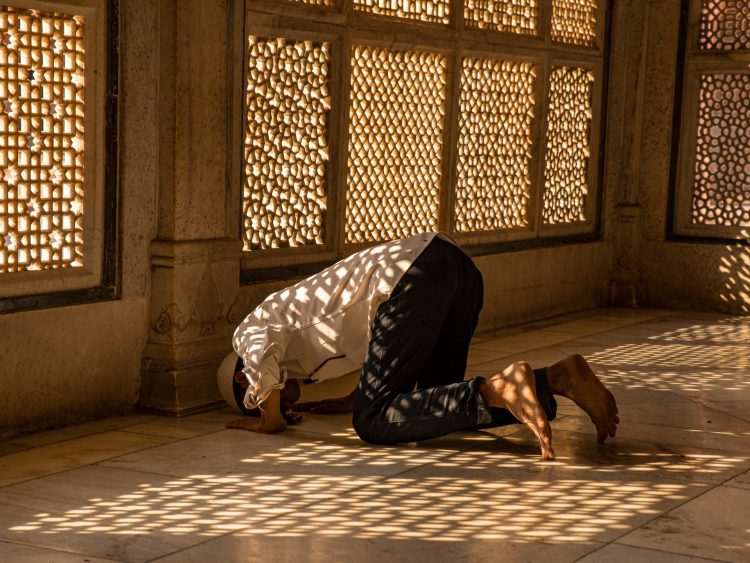 Sussurros na Luz
Um fiel solitário curva-se em oração dentro de uma câmara iluminada pelo sol, onde janelas rendilhadas projetam sombras padronizadas sobre o piso de mármore. O jogo entre luz e devoção revela a força íntima da fé em tempos incertos. Fatehpur Sikri, Índia, 2013