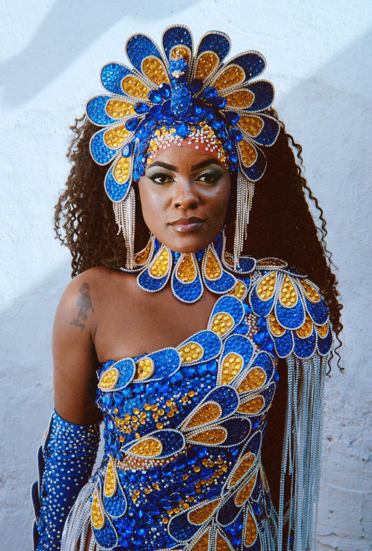 Nathanny, Rio 2024 
Nathanny é uma das cinco musas da escola de samba Unidos da Tijuca. Ela ocupa a segunda
posição na hierarquia das dançarinas, logo atrás da única rainha e à frente do grupo de passistas. Nathanny foi passista durante doze anos, o que a torna a dançarina mais dedicada e experiente do grupo. Ela foi escolhida pelo presidente da escola, ao contrário das outras quatro musas, que pagam por suas posições. Naquele dia, ela havia acabado de terminar sua preparação para uma apresentação de dança. Seu figurino de pavão, símbolo da escola Unidos da Tijuca, lhe conferia uma presença magnífica.