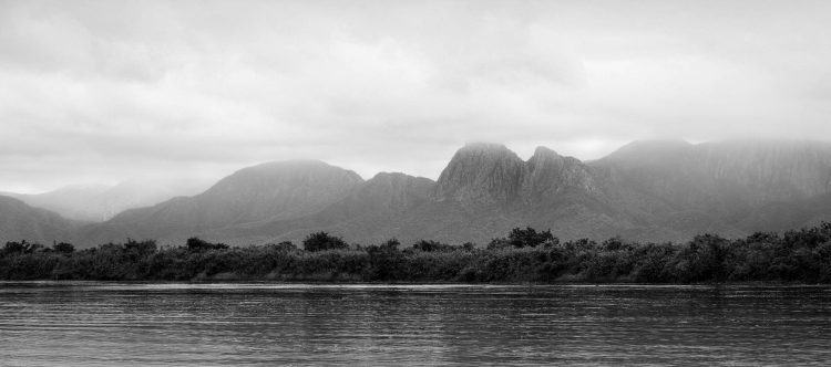 Primeira Suspensão
A paisagem emerge lentamente, entre névoa e relevo, como um território que ainda não se revela por completo.
