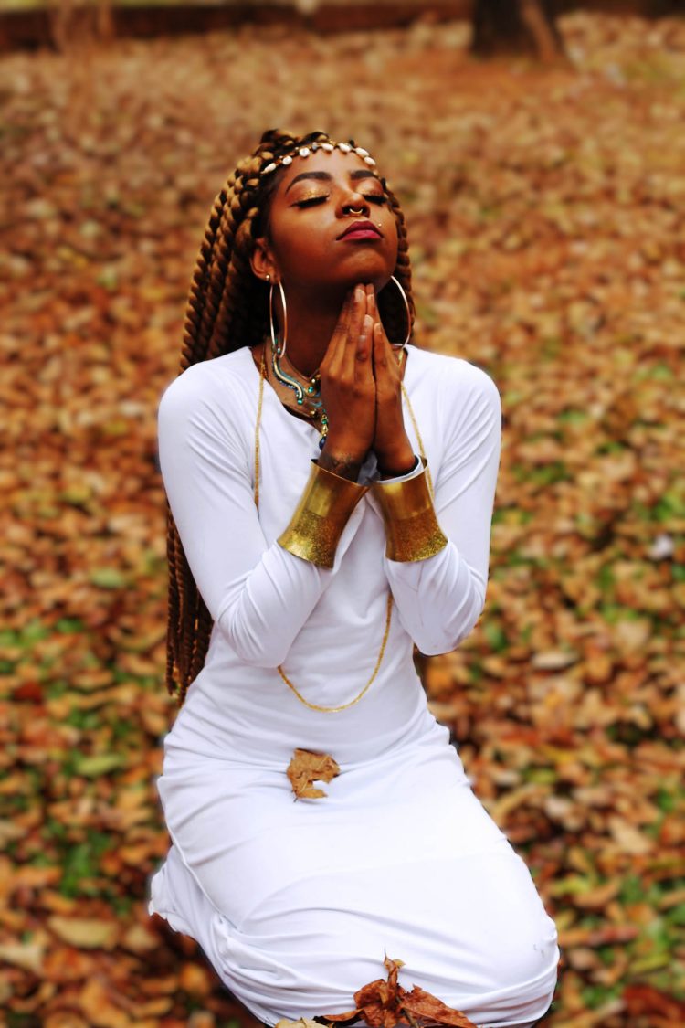 Oração Ancestral "Em trajes brancos e adornos tradicionais, o corpo em gesto de oração transmite espiritualidade e resistência. É contemplação e força interior, memória ancestral que floresce no presente."