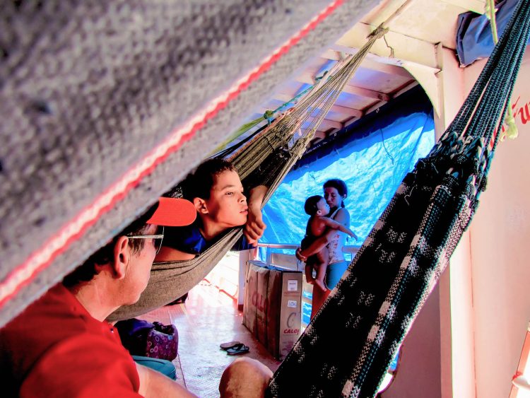 O conforto do colo da mãe em meio ao labirinto das redes no limitado espaço compartilhado durante as longas jornadas sobre as águas.